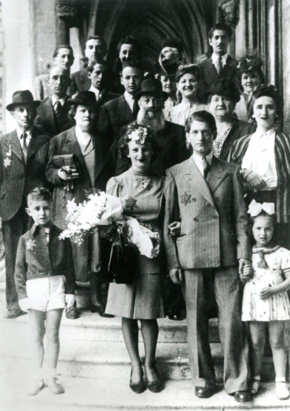 一张黑白照片，一个婚礼派对站在建筑物的台阶上