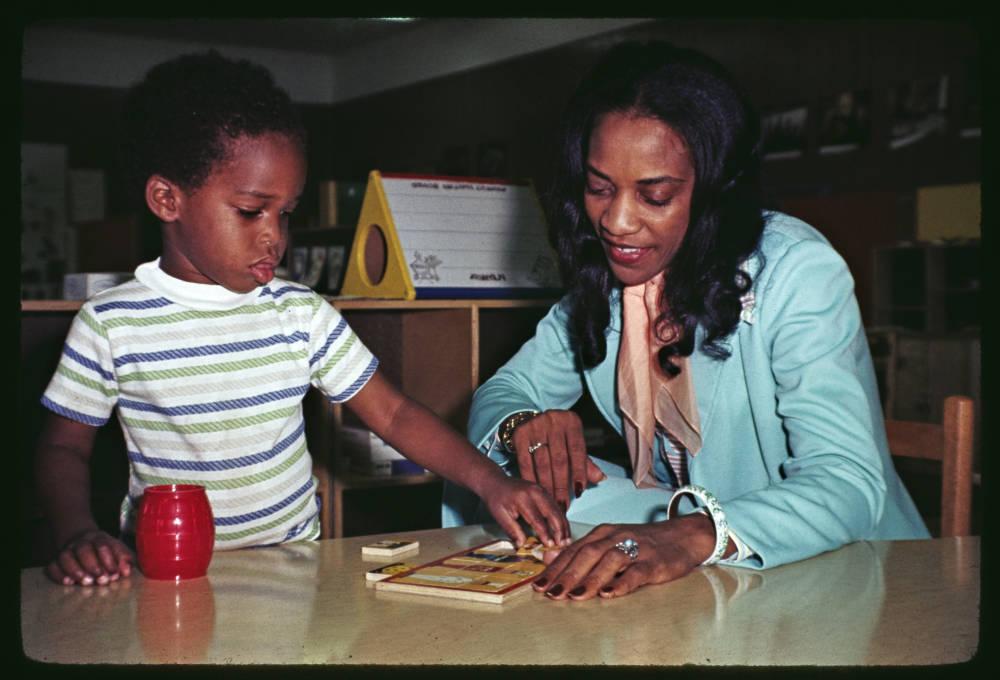 一个女人和一个小男孩在看桌子上的拼图的彩色照片